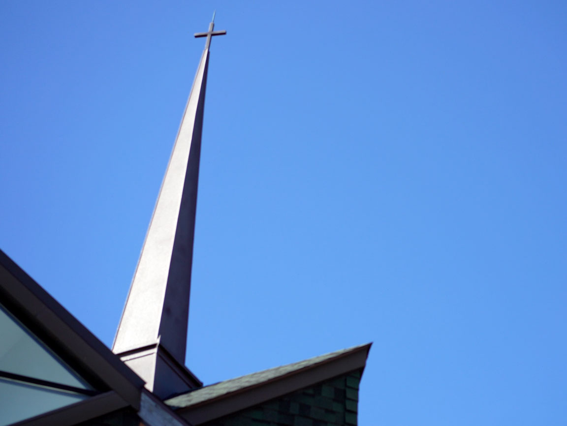Looking up at a church spire, blue sky in the background