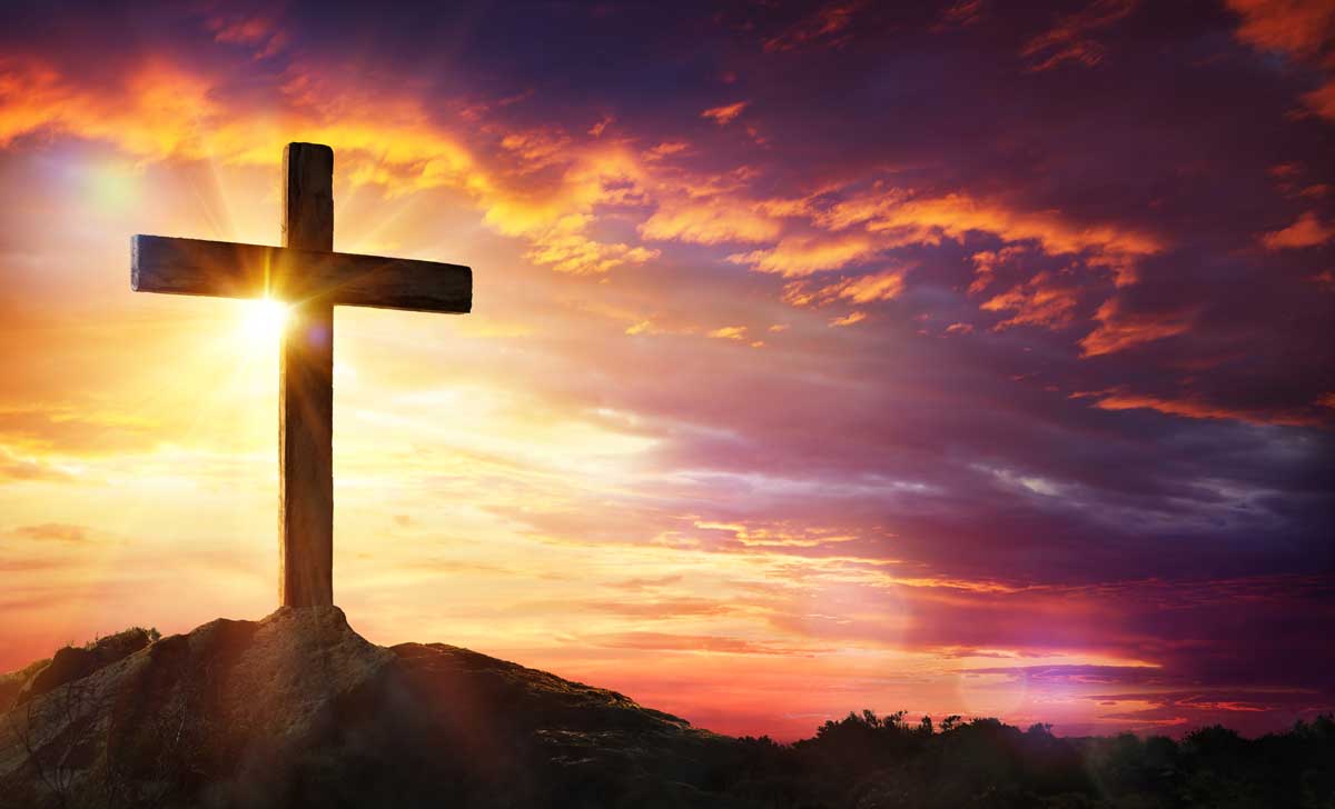 Wooden Cross against backdrop of sunset